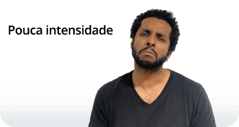 Composição com texto e fotografia. À esquerda, está escrito “Pouca intensidade” em letras pretas. À direita, um homem de pele parda, cabelos cacheados, curtos e pretos, e barba preta, com o corpo voltado para frente e a cabeça levemente inclinada para a direita. Ele olha para a frente com os olhos semicerrados, testa franzida e os lábios juntos, curvados para baixo