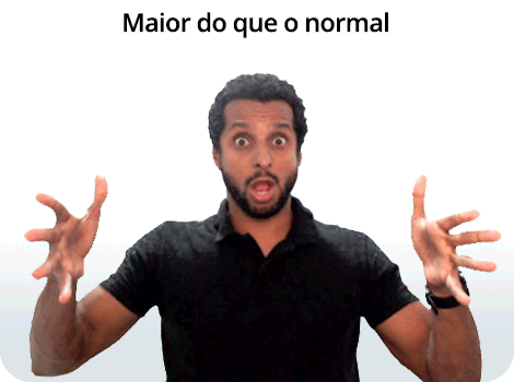 Composição com texto e fotografia. Na parte superior, está escrito “Maior do que o normal” em letras pretas. Abaixo, um homem de pele parda, cabelos cacheados, curtos e pretos, e barba preta, com o corpo voltado para frente. Ele aparece da barriga para cima, com os olhos bem abertos, sobrancelhas erguidas e a boca aberta. Os braços estão erguidos, com as mãos abertas, na altura dos ombros, dedos estendidos, afastados uns dos outros e voltados para frente.